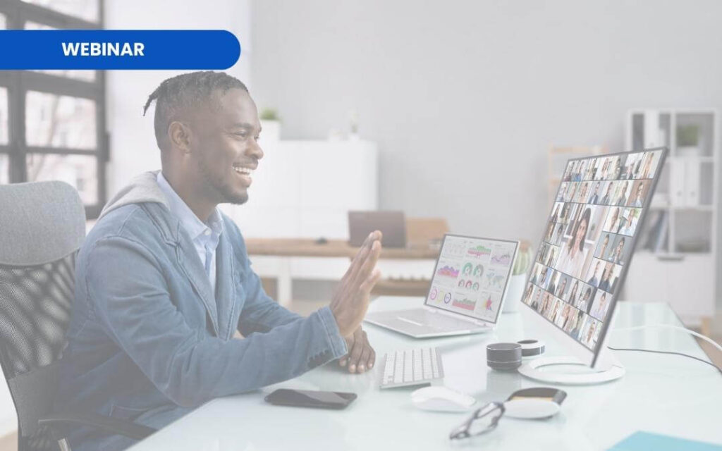 A Black man smiling in front of the computer while on a video call